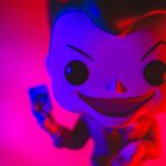 unusual toy of superhero in bright violet light